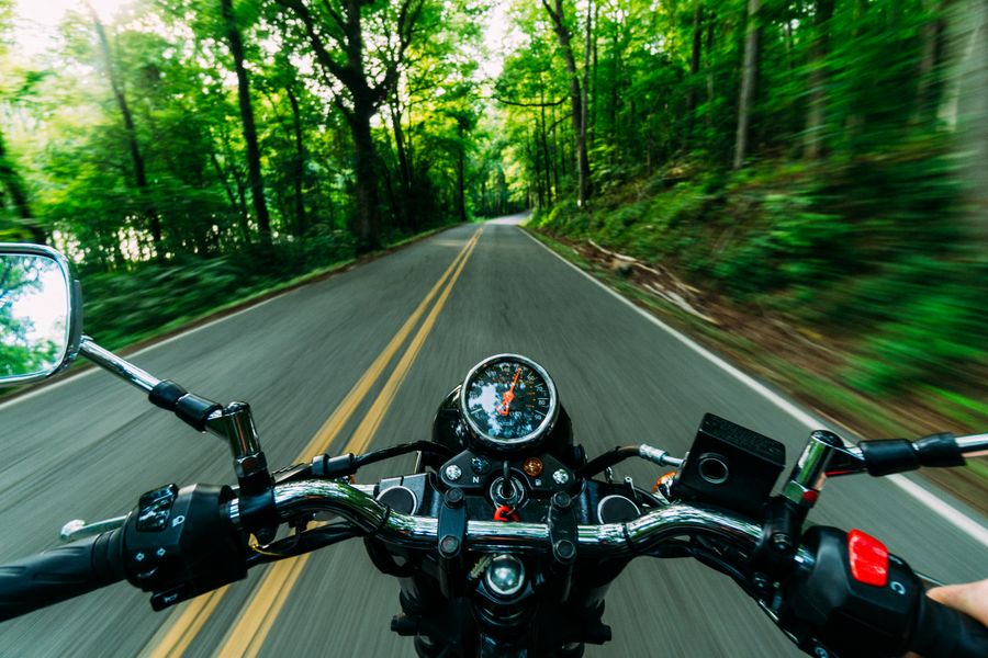Recorriendo una carretera tropical entre la selva en moto